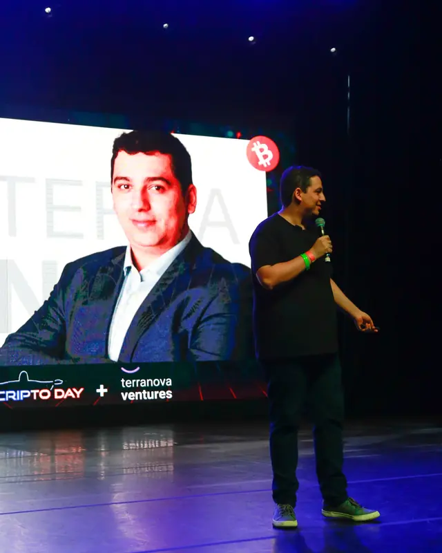 Terranova no palco de um evento no Rio, ao lado do telão com o retrato dele